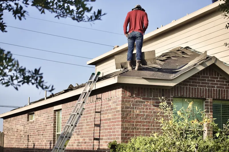Professional roofer working on a residential roof in Willow Forest
